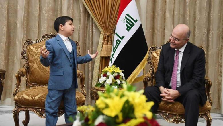 الجواهري الصغير أثناء إلقائه قصيدة أمام الرئيس العراقي برهم صالح (الجزيرة)